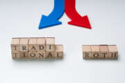 Red And Blue Directional Arrows Showing Traditional And Roth Ira Options On Wooden Blocks