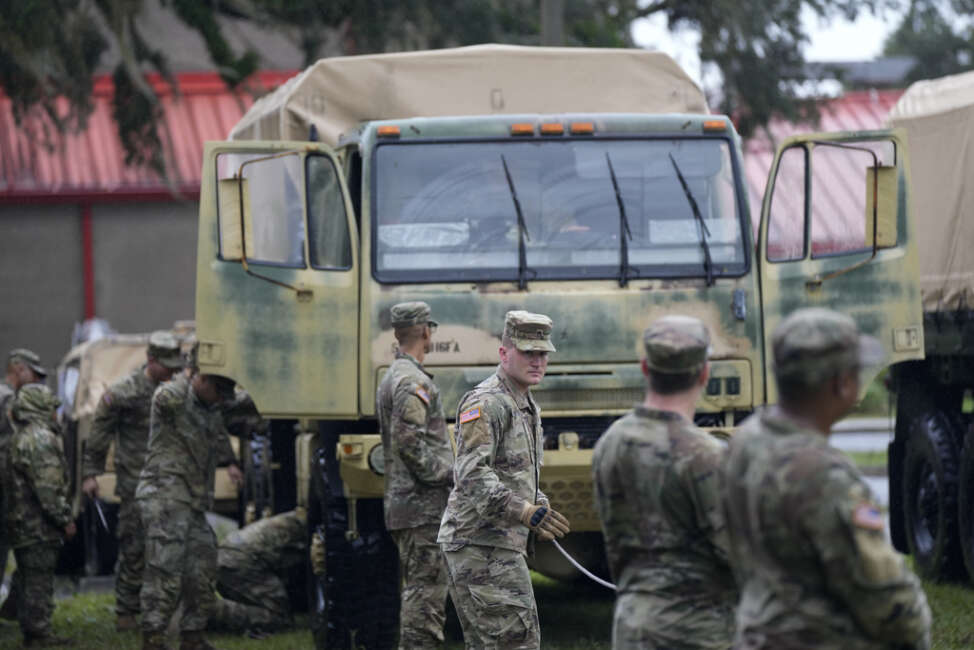 Members of the National Guard prepare their equipment in Mayo, Fla., as they wait for instructions on where to respond, after the passage of Hurricane Idalia, Wednesday, Aug. 30, 2023. (AP Photo/Rebecca Blackwell)