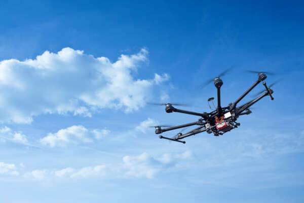 Copter flight against the blue sky. RC aerial drone.