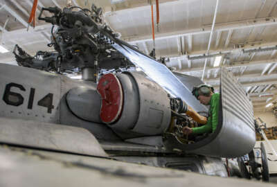 Mechanic performs maintenance on an MH-60S Sea Hawk helicopter aboard the aircraft carrier USS Nimitz