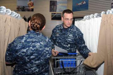 Navy Chief Air Traffic Controller (Select) Christopher Ollinger searches for the right fit of khaki pants.