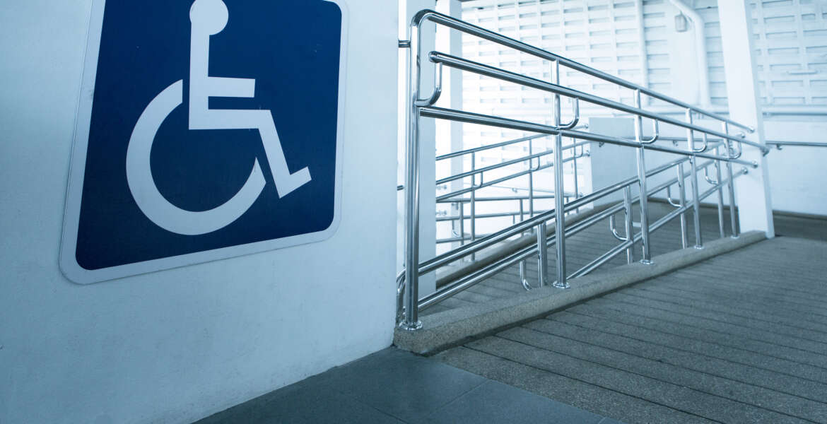 Concret ramp way with stainless steel handrail with disabled sign for support wheelchair disabled people.