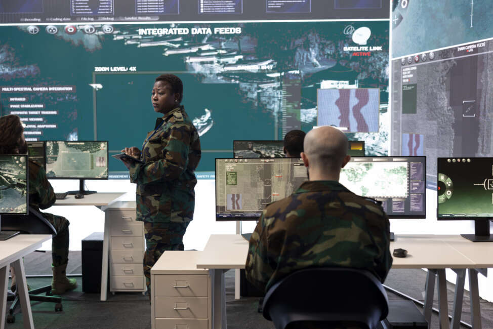 Female master sergeant gathers battlefield intelligence reports on a big screen