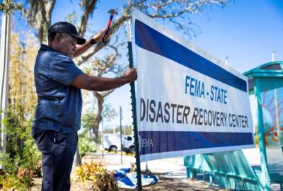 FEMA employee putting up a sign