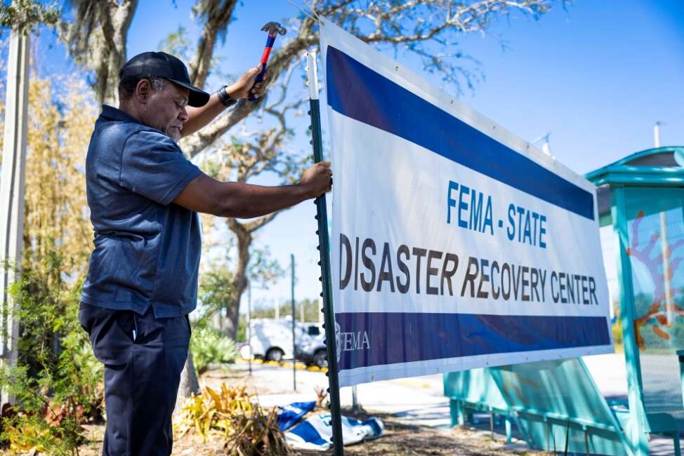 FEMA employee putting up a sign