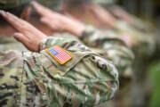 Detail shot with American flag on soldier uniform, giving the honor salute during military ceremony