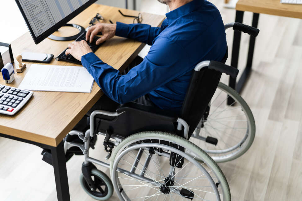 Disabled man in a wheelchair using a computer