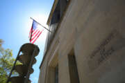 U.S. Department of Justice building and the American flag under the sun