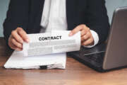 Businessman in a suit tearing up a contract while sitting at the table